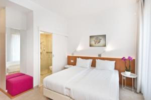 a bedroom with a white bed and a pink chair at Villa 21 Victus by Noclegi Renters in Sopot