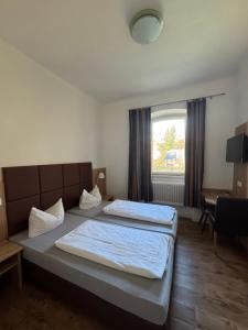 a bedroom with two beds and a window at Landgasthof Heerlein in Bamberg