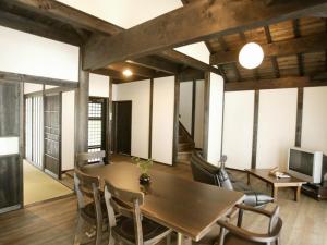 a room with a table and chairs and a television at Nagomiya Hirugano in Gujo