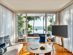 a living room with a couch and a tv at InterContinental Hua Hin Resort by IHG in Hua Hin