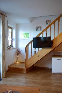 a living room with a staircase with a flat screen tv at Ferienwohnung Seeufer in Bad Bayersoien