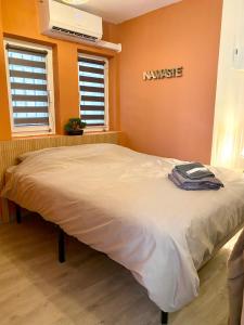 a large bed in a room with orange walls at Studio confortable au centre de Manosque in Manosque
