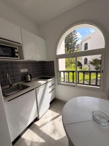 a kitchen with a window and a sink and a table at Résidence Neffati in Hammamet