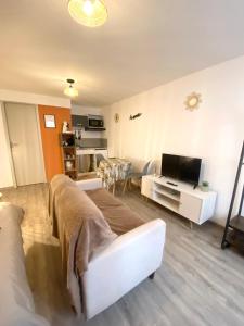 a living room with a white couch and a television at Studio confortable au centre de Manosque in Manosque