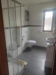 a bathroom with a toilet and a glass shower at Unterkunft Mau in Rotenburg an der Wümme