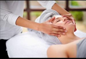a woman getting her face washed by a therapist at Les Troglos de la Tufolière in Rochecorbon