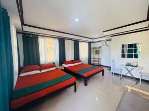a bedroom with two beds and a couch and a table at Tuburan Resort in Panong +1 photo