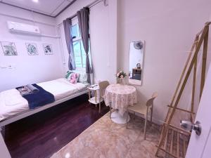 a small room with a bed and a table at Pion Hotel Ayutthaya in Phra Nakhon Si Ayutthaya