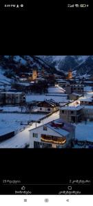 two pictures of a city with snow and buildings at Mariana's Guest House in Mestia