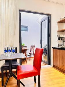 a dining room with a table and a red chair at Happy House in Danang