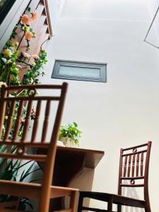 a room with two chairs and a table with flowers at Happy House in Danang