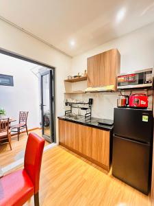 a kitchen with a black refrigerator and a red chair at Happy House in Danang +19 photos