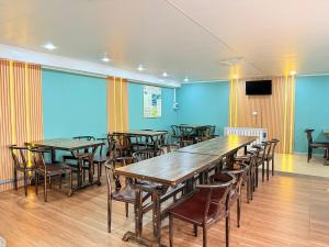 a conference room with tables and chairs and a tv at MONKHSUURI GUESTHOUSE in Harhorin