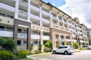 a white car parked in front of a large building at One Oasis Condo beside SM Mall in Davao City