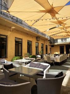 an outdoor patio with tables and chairs and umbrellas at Hotel 52 in Odesa