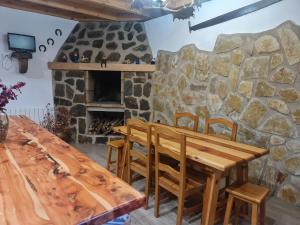 a wooden table and chairs in front of a stone fireplace at CASA La Playeta in Puente de Vadillos