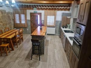 a kitchen with a wooden counter top and a table at CASA La Playeta in Puente de Vadillos