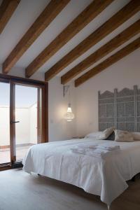 a bedroom with a large bed and a large window at Casas de Valois in Hita