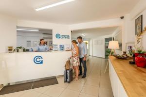 a man and woman standing at the counter of a pharmacy at Artemis Cynthia Complex in Paphos +126 photos