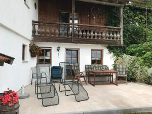 a patio with chairs and a table and a balcony at Ferienwohnung Seeufer in Bad Bayersoien