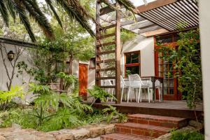 a house with a porch with a table and chairs at Camps Bay Village in Cape Town