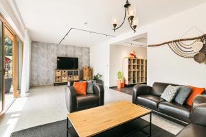 ein Wohnzimmer mit Ledermöbeln und einem Fernseher in der Unterkunft Hotel Helios in Lipová-lázně
