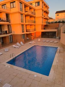 a swimming pool in front of a building at T1 Praia Areia Branca in Lourinhã