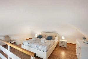 a white bedroom with a bed and a staircase at La Volta Amalfi Coast in Furore