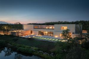 a large house with a river in front of it at PLAN B00b7ANADOL in Xianning