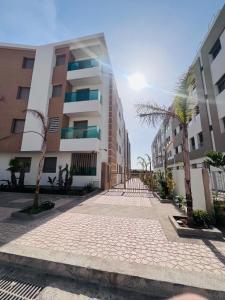 a street in front of a building with palm trees at Luxury Appartement fes city fleur in Fez