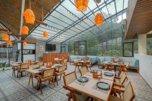 a restaurant with wooden tables and chairs and glass ceilings at Nirvana By Nest Kasauli 2 BHK Luxury Apartment Rooftop Cafe Free Parking in Kasauli