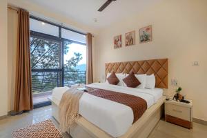 a bedroom with a large bed and a large window at Nirvana By Nest Kasauli 2 BHK Luxury Apartment Rooftop Cafe Free Parking in Kasauli