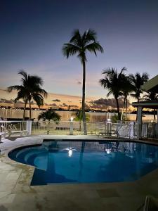 a large swimming pool with palm trees in the background at Coconest - Duplex on the beach in Baie Nettle