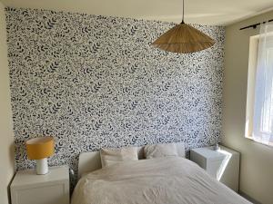 a bedroom with a patterned wall with a bed at Gîte Chez Paddy in Ladoix Serrigny