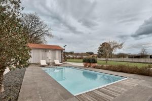 a swimming pool in a yard with two chairs and a house at Casa Das Ferreñas in Melide