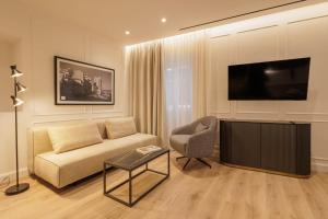 a living room with a couch and a flat screen tv at Mouragia by Kantoni in Corfu
