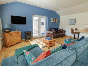 a living room with a couch and a tv at Trillo Lodge in Colwyn Bay