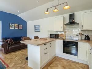 a kitchen with white cabinets and a living room at Trillo Lodge in Colwyn Bay +10 photos