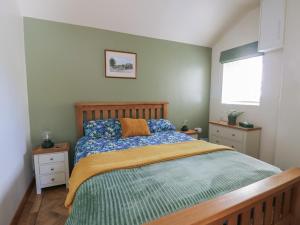 a bedroom with a bed with a wooden head board at Trillo Lodge in Colwyn Bay