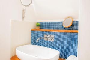 a bathroom with a white toilet and blue tiles at Manzi 40 in Civitavecchia