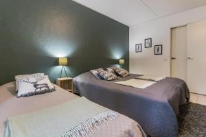 a bedroom with two beds and a green wall at Kotokatti in Vuokatti
