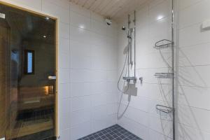 a shower in a white tiled bathroom at Kotokatti in Vuokatti +13 photos