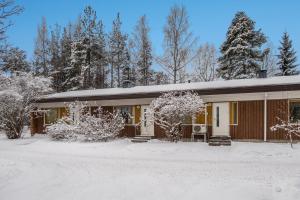 a house in the snow with snow covered trees at Kotokatti in Vuokatti