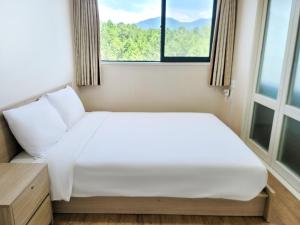 a white bed in a room with a window at Jiri Mountain Ilsung Condo in Namwon