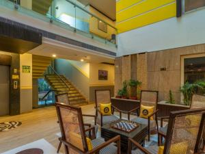 a lobby with chairs and a table and stairs at The Hosteller Delhi in New Delhi +15 photos