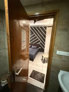 a small bathroom with a bed and a sink at Luxe Haven Stays - Luxury Studio , Premium Stay in Noida