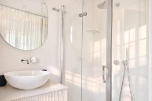 a white bathroom with a sink and a shower at Señorial Panorámico by apartamentoscatedralcamino in Burgos +24 photos