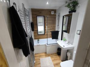 a bathroom with a sink and a tub and a toilet at Carrick's Cosy Haven in Carrickfergus +24 photos