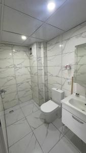 a white bathroom with a toilet and a sink at Köşk Rezidans Apart in Aksaray +52 photos