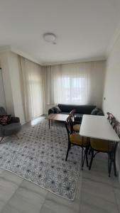 a living room with a couch and a table and chairs at Köşk Rezidans Apart in Aksaray